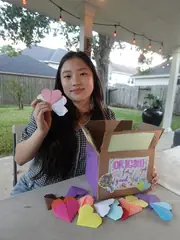 Vivian holding an origami heart for Origami For Good